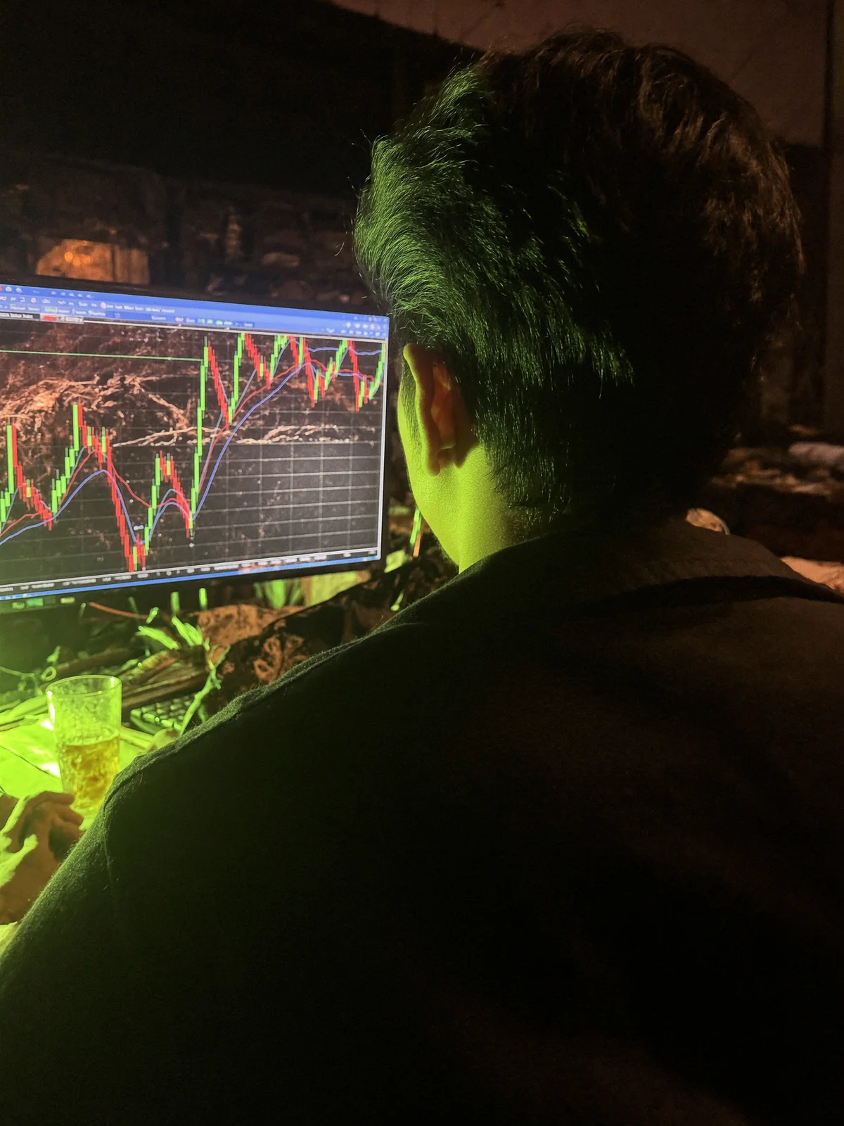 Over-the-shoulder view of market charts on a monitor late at night